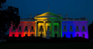 casa branca iluminada com as cores do arco-íris